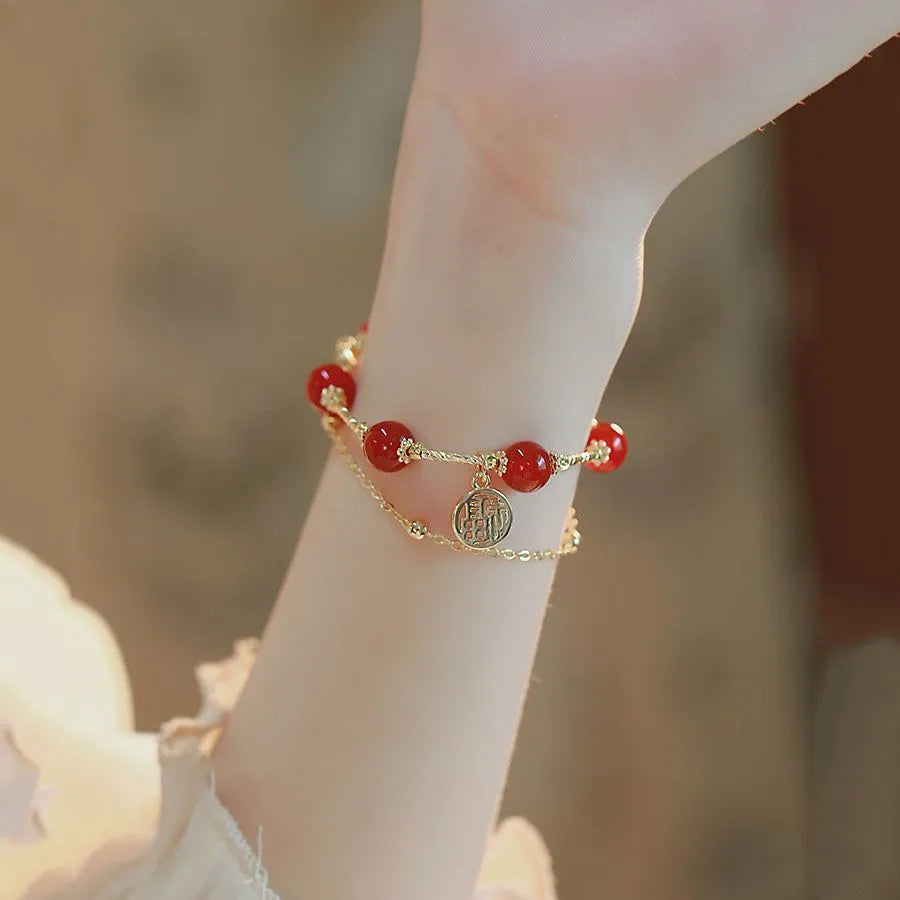 Red agate and alloy double-layer women's bracelet with Hongma blessing card charm on an adjustable fastening.
