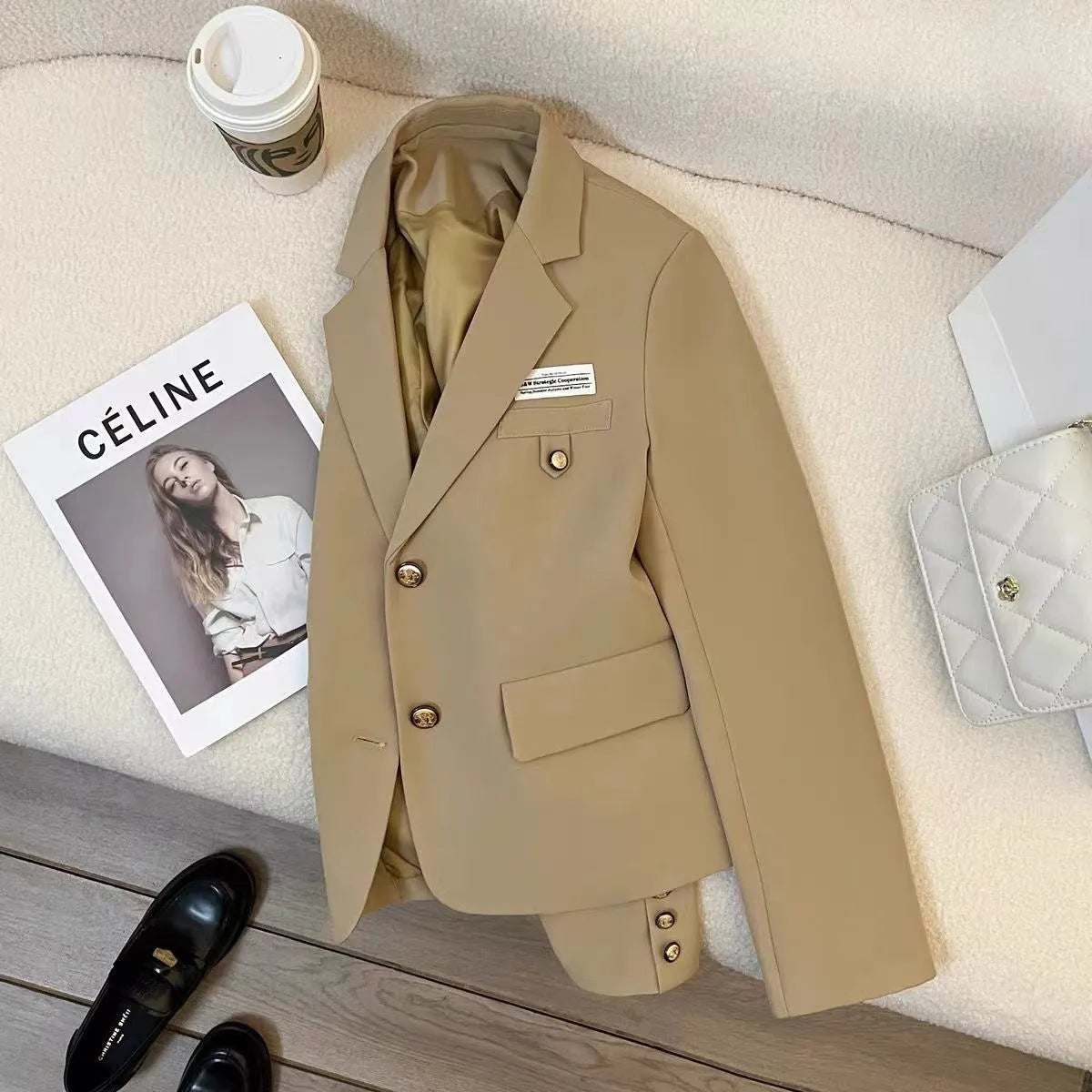 Women's black short suit coat with loose fit, long sleeves, and pocket details