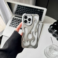 Electroplated hollow flame pattern TPU phone case for iPhone on a table, showing silver metallic finish and ventilation design.