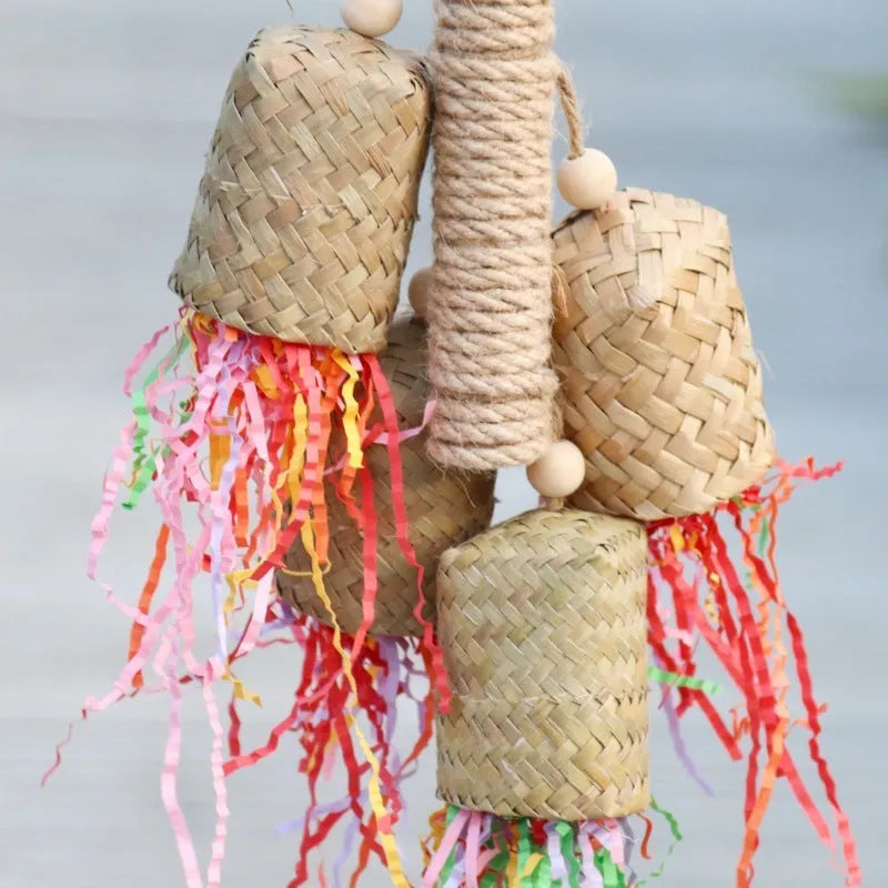 A parrot toy made of wood and sisal rope with colourful shredded paper attachments.