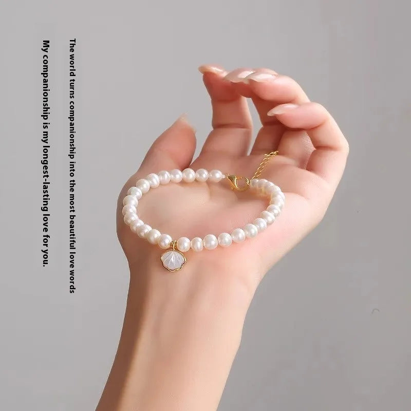 A women's bracelet with a fan-shaped arrangement of small freshwater pearls on a 16cm elastic string.