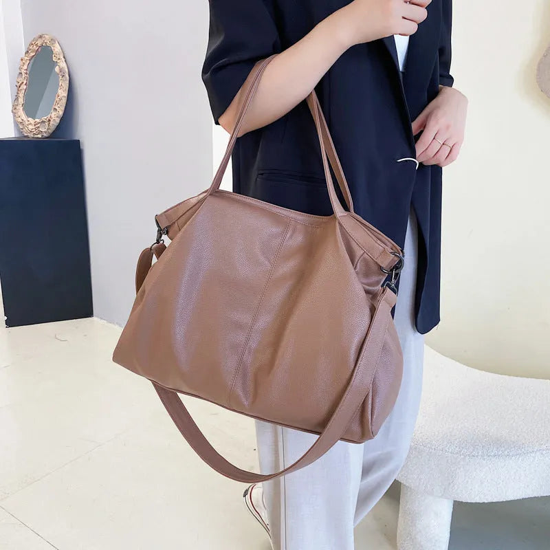 Large soft surface PU messenger tote bag in black with adjustable shoulder strap and zipper opening.