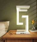 White magnetic suspension table lamp with wireless charging base, floating shade, and foldable bracket on a desk