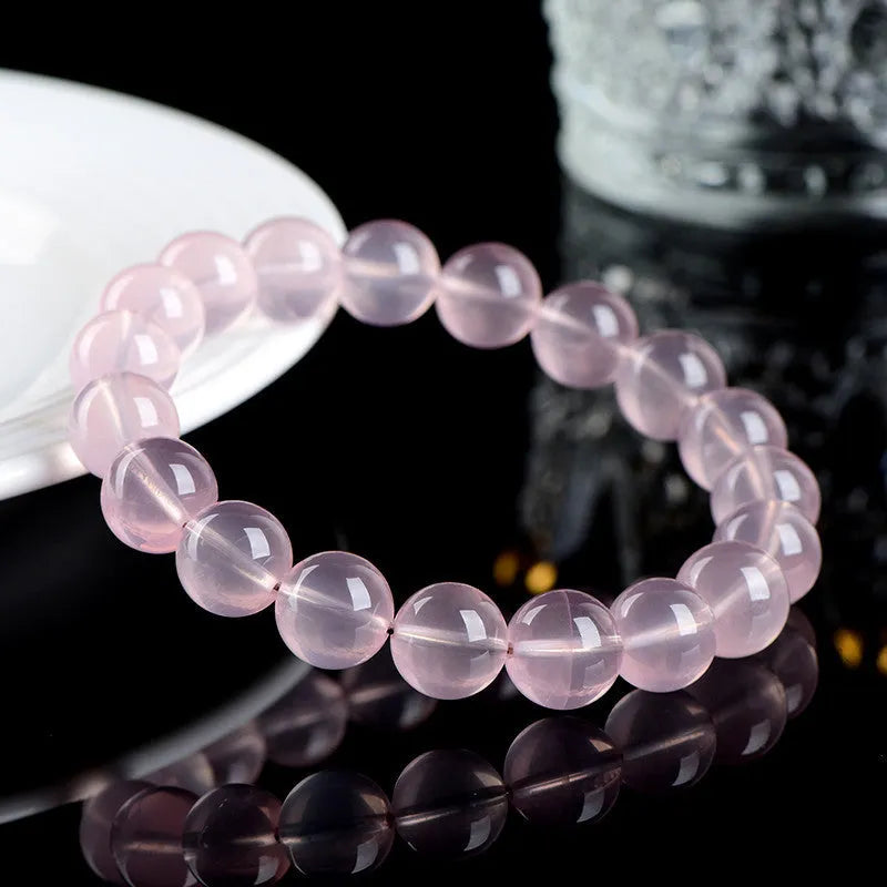 Natural pink starlight crystal round bead bracelet with polished 10mm stones on elastic cord