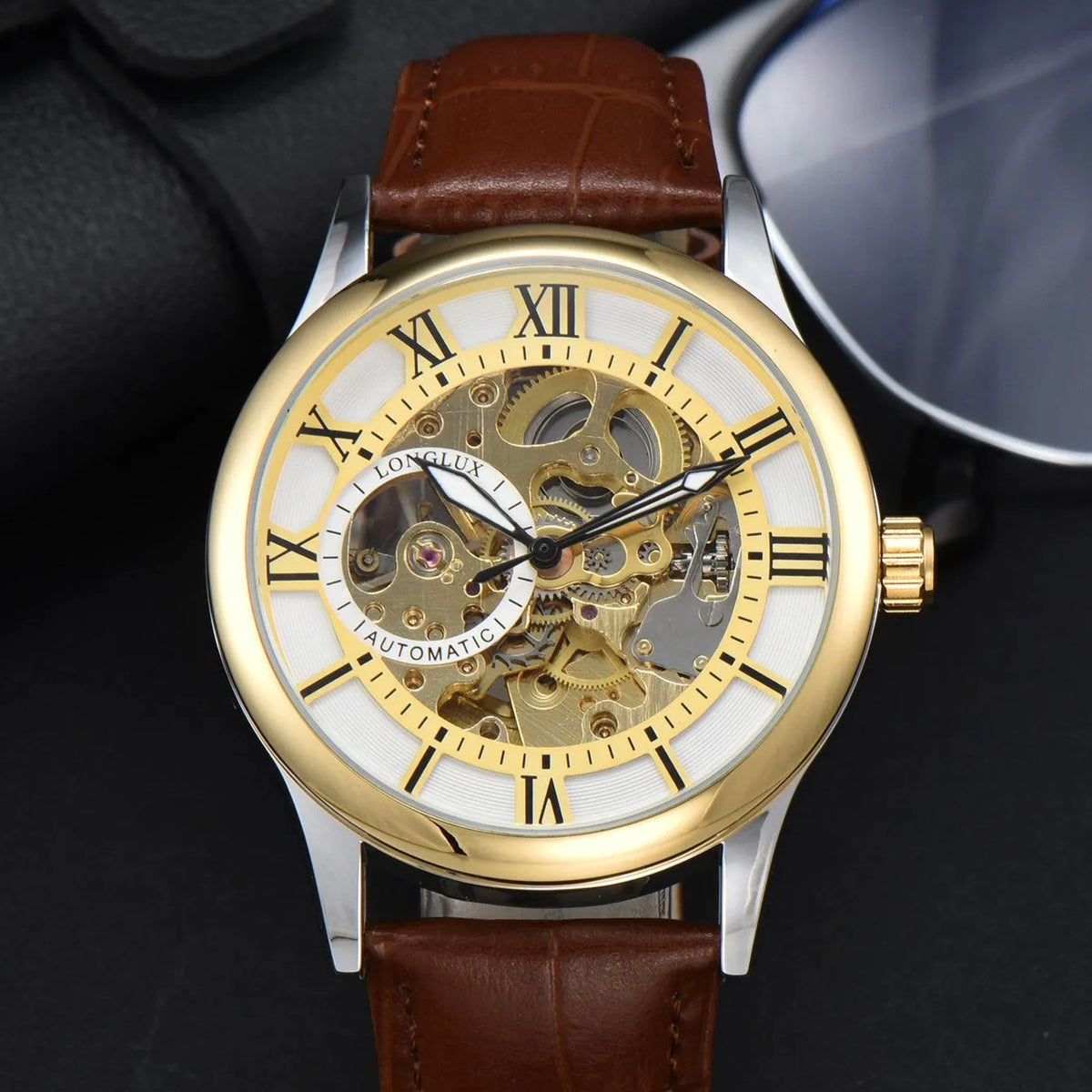 Men's mechanical watch with Roman scale dial, metal case, and faux leather strap on wrist