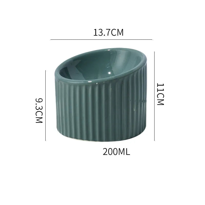 Dark green ceramic elevated cat bowl with tilted design on a raised platform.