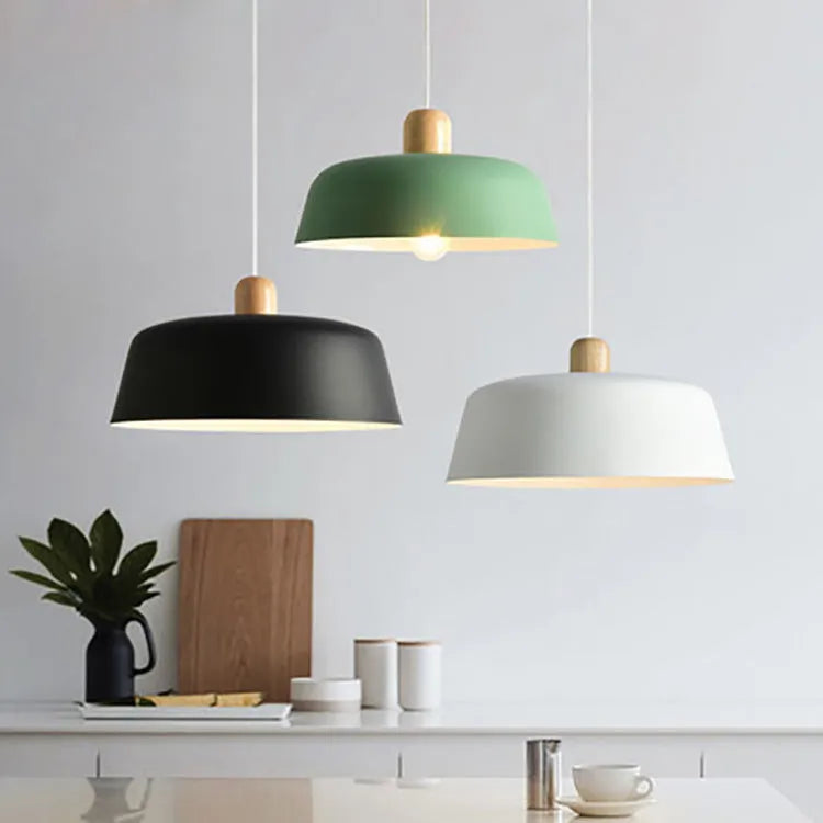 Nordic round zinc alloy pendant light in black with adjustable suspension height over a wooden dining table