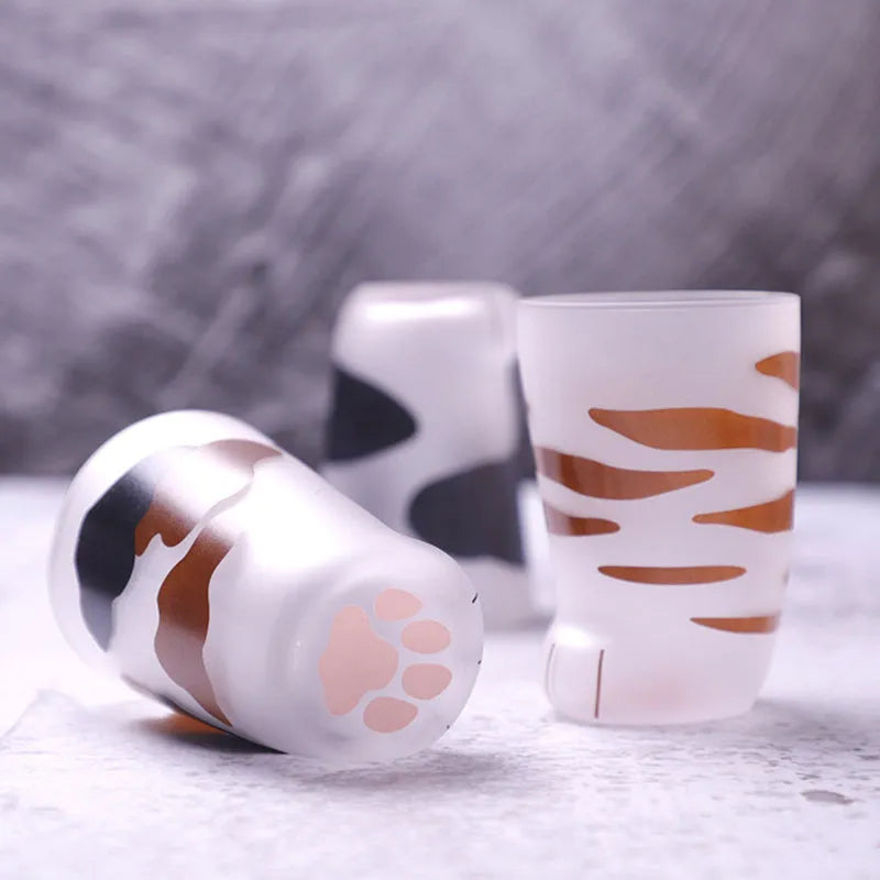 Creative cat paw shaped glass mug with 300ml capacity and frosted texture on a desk