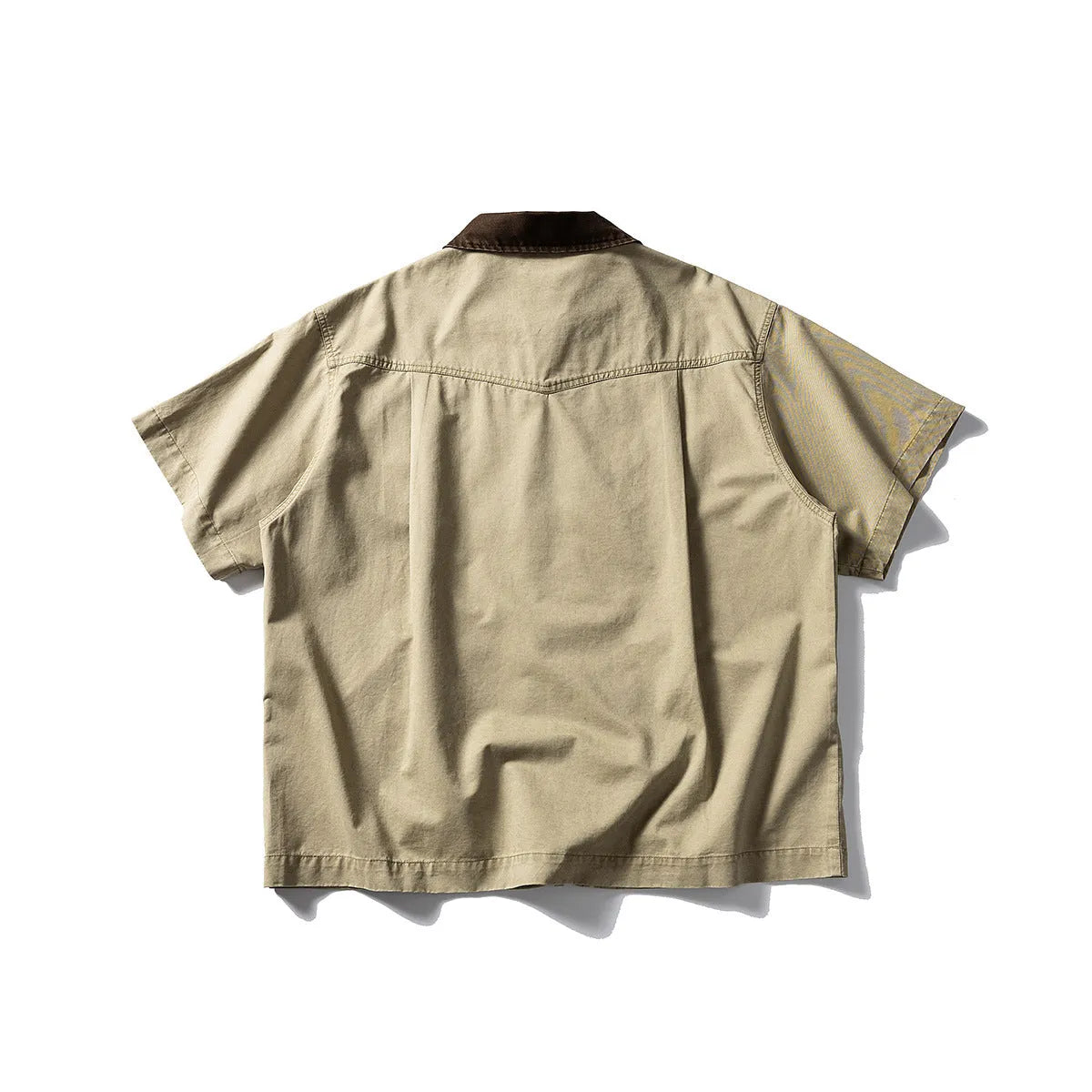 A khaki washed cotton overalls shirt with short sleeves and a loose cardigan style, laid flat.