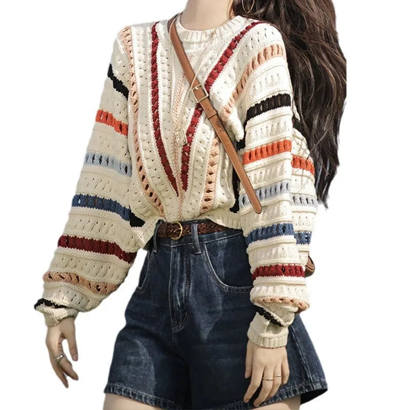 Retro rainbow striped hollow pullover sweater with batwing sleeves on a hanger.