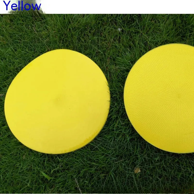 Circular yellow football training marker disc on grass field showing 23cm diameter