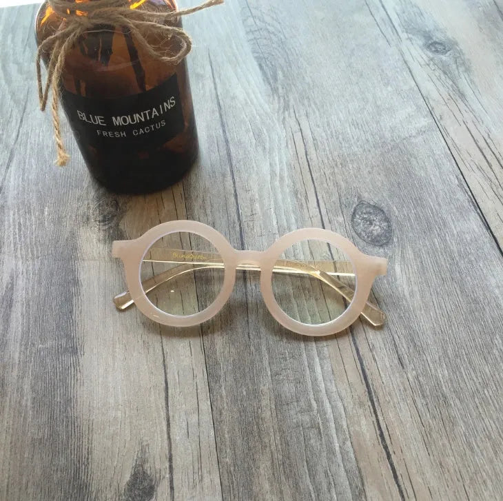 Retro round frame anti blue light glasses in multiple colours on a plain background.