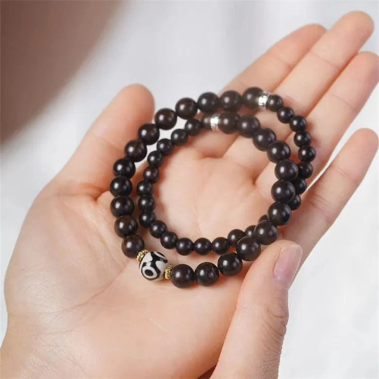 Dark ebony wood bracelet with 8mm Tibetan style beads showing two-circle pattern design