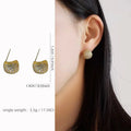 Geometric drop-shaped earrings with full diamond detailing, spherical elements, and little golden beans motif in gold or white colour