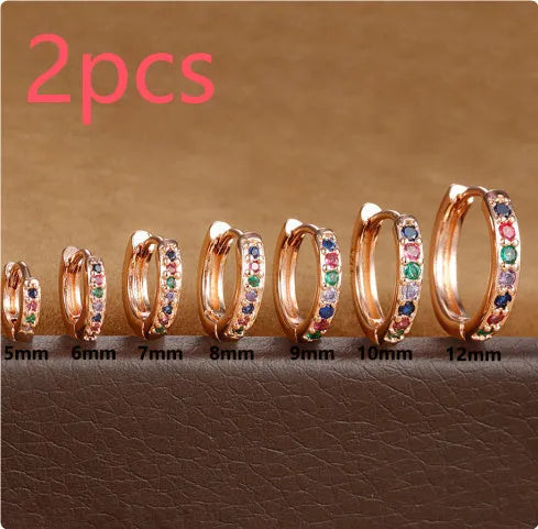 Perforated circular zircon stud earrings in gold, rose gold, and silver colours showing geometric design.