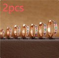 Perforated circular zircon stud earrings in gold, rose gold, and silver colours showing geometric design.