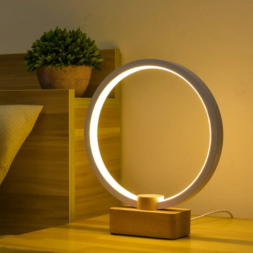 Round small solid wood and bamboo USB-powered LED night lamp on a table.