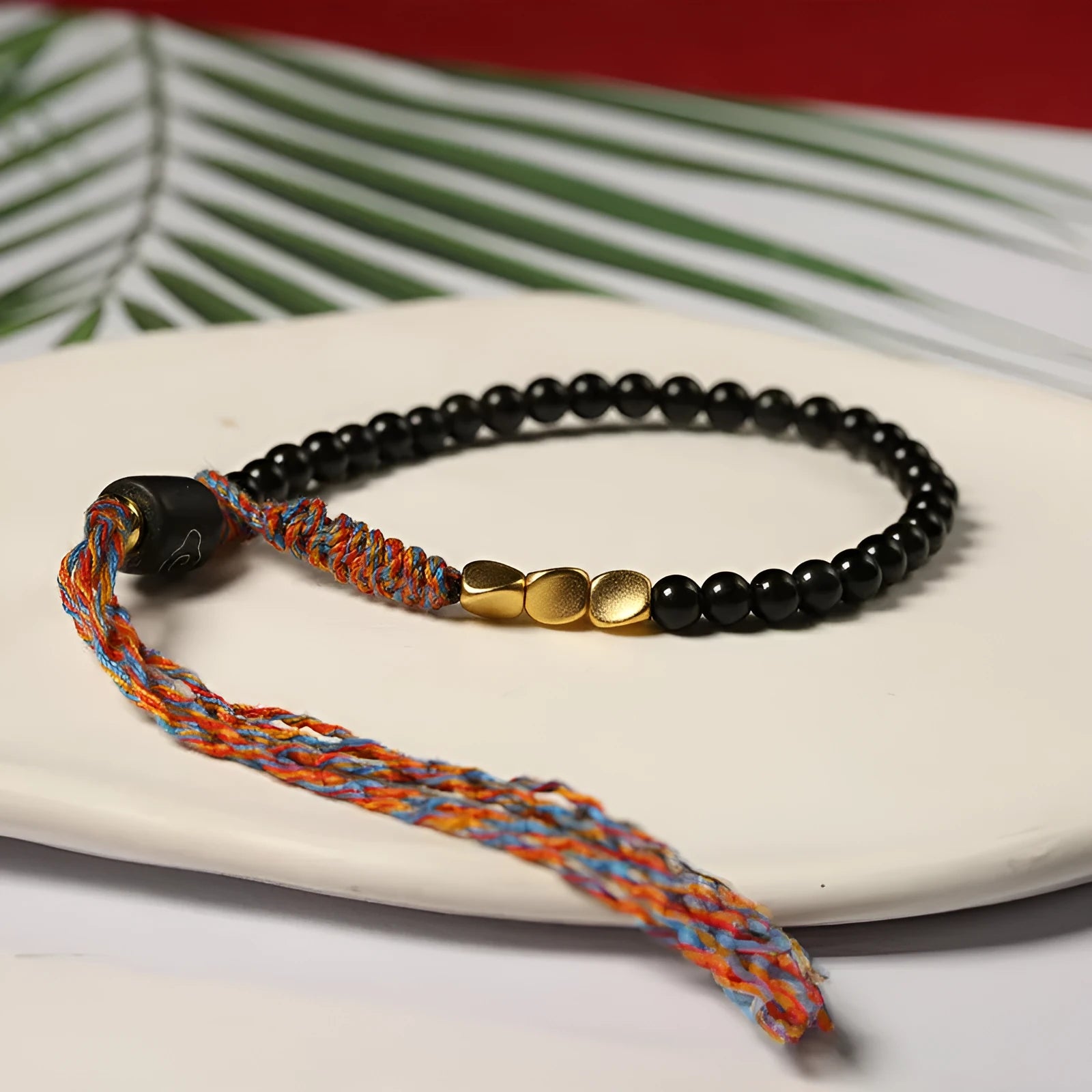 Hand-woven obsidian carrying strap bracelet showing textured surface and adjustable length