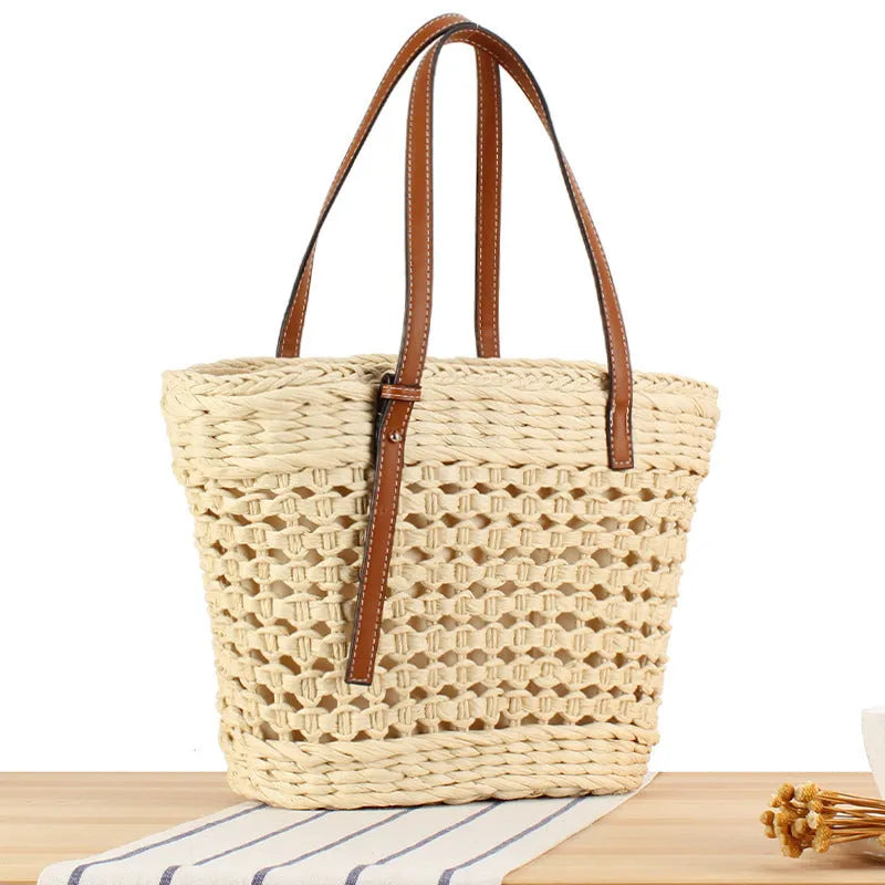 Paper woven shoulder bag with adjustable strap in beige colour showing horizontal square shape and straw decorative elements