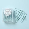 Macaron-color paper clips in pastel shades including pink, green, and purple on a white desk