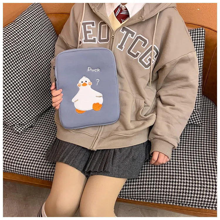 Blue cotton tablet case with an embroidered cartoon duck design and a silver zip closure.