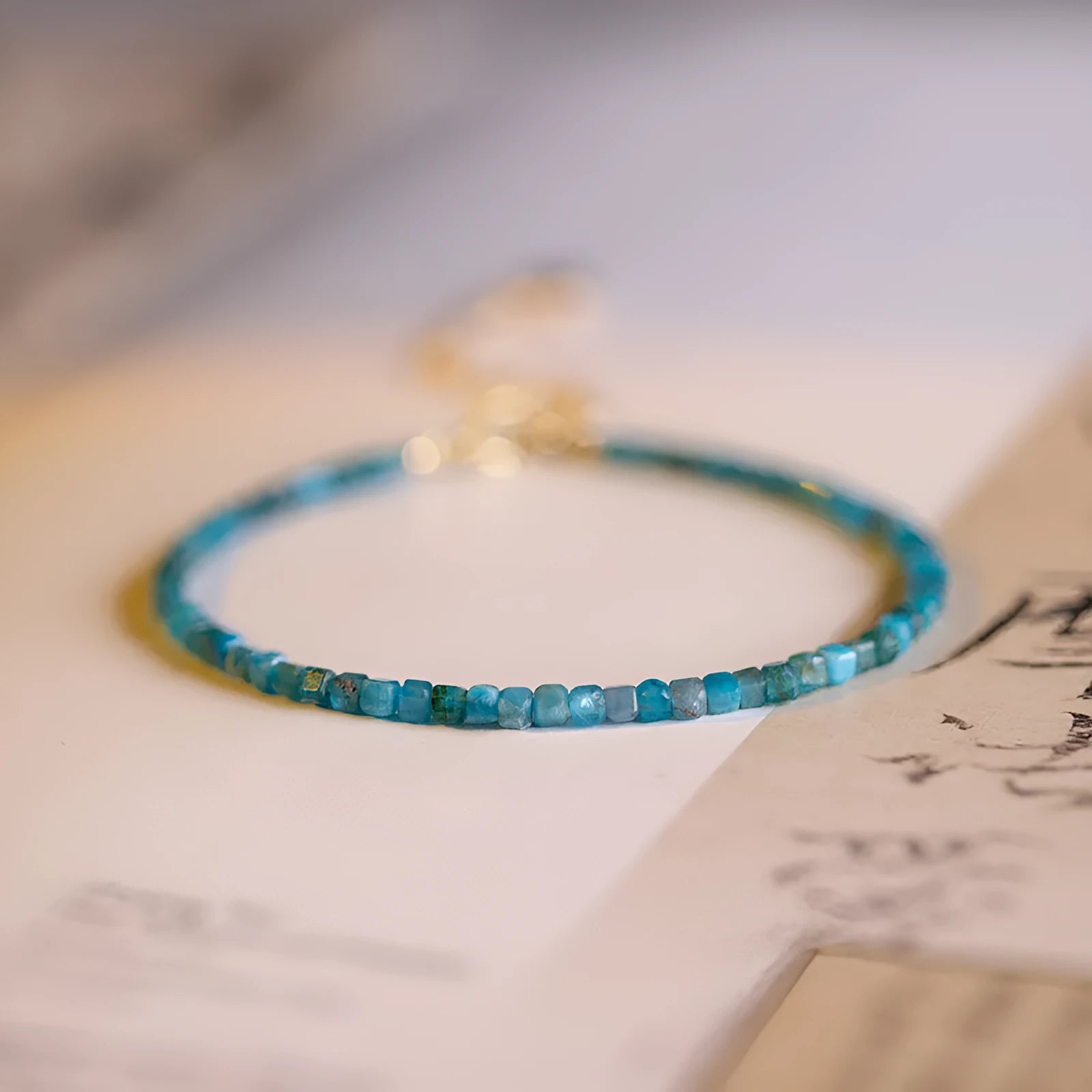 Women's blue and grey apatite crystal bracelet with diamond-cut stones on a wrist.