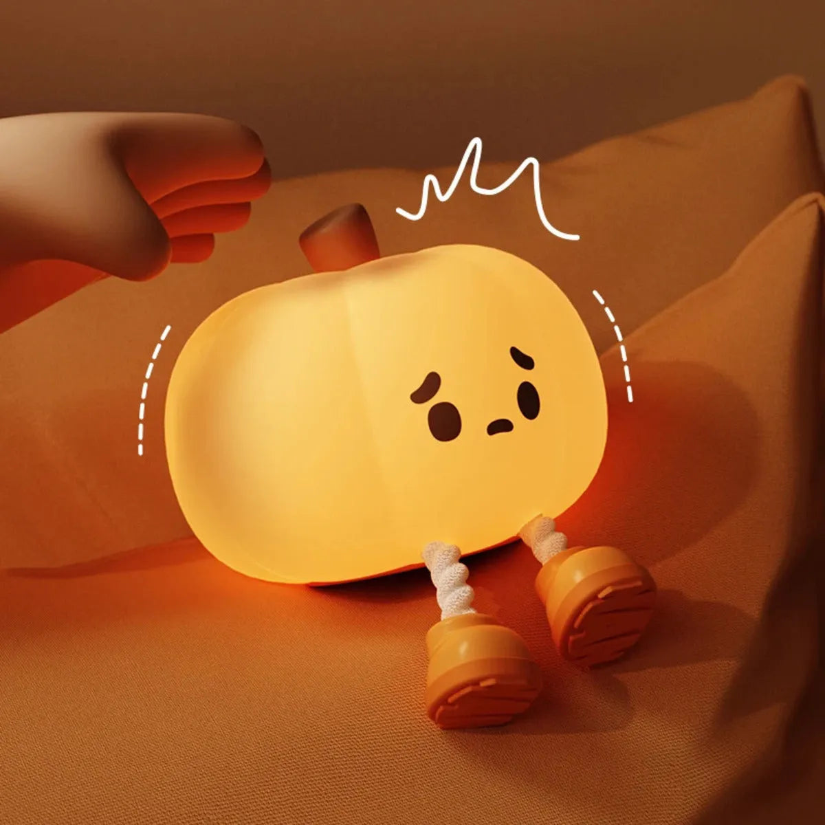 Pumpkin-shaped silicone night light with rechargeable battery on a bedside table