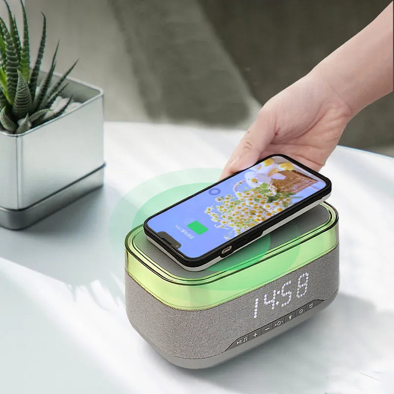 White multifunctional alarm clock with Bluetooth speaker and wireless charging pad showing night light illumination
