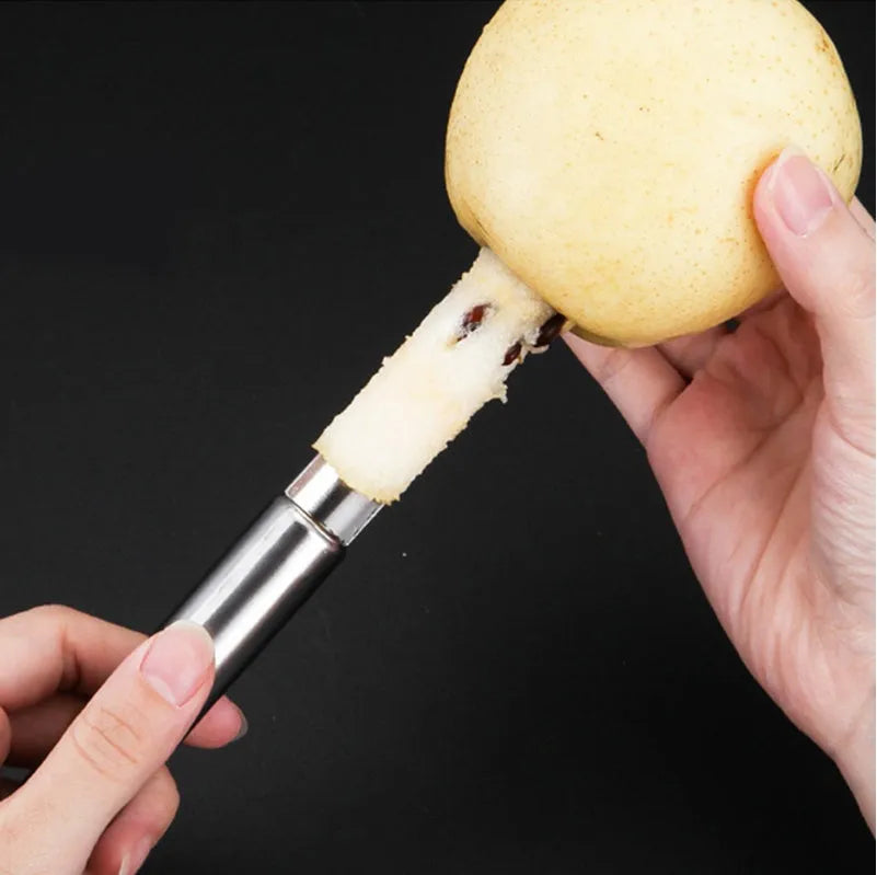 Stainless steel pineapple corer slicer with black plastic handle on a kitchen worktop.