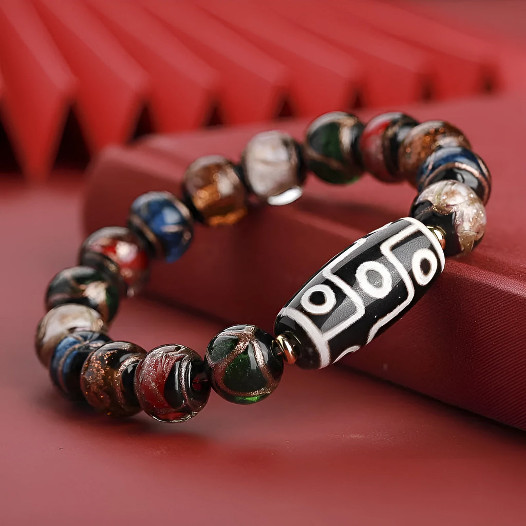 Close-up of a handcrafted coloured glaze bracelet with multi-colour lucky beads and auspicious Chinese patterns.