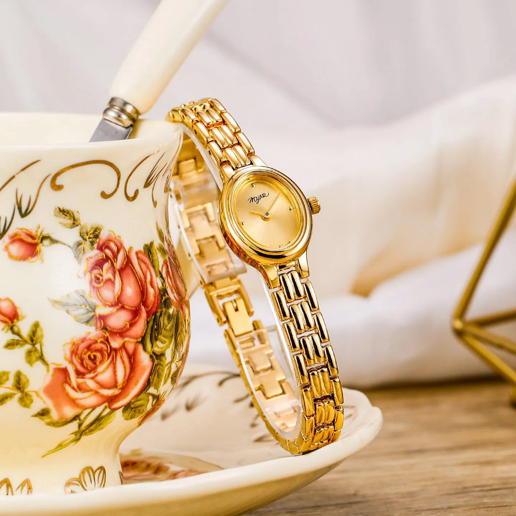 Oval mini women's vintage quartz watch with gold alloy case, white dial, and jewellery buckle