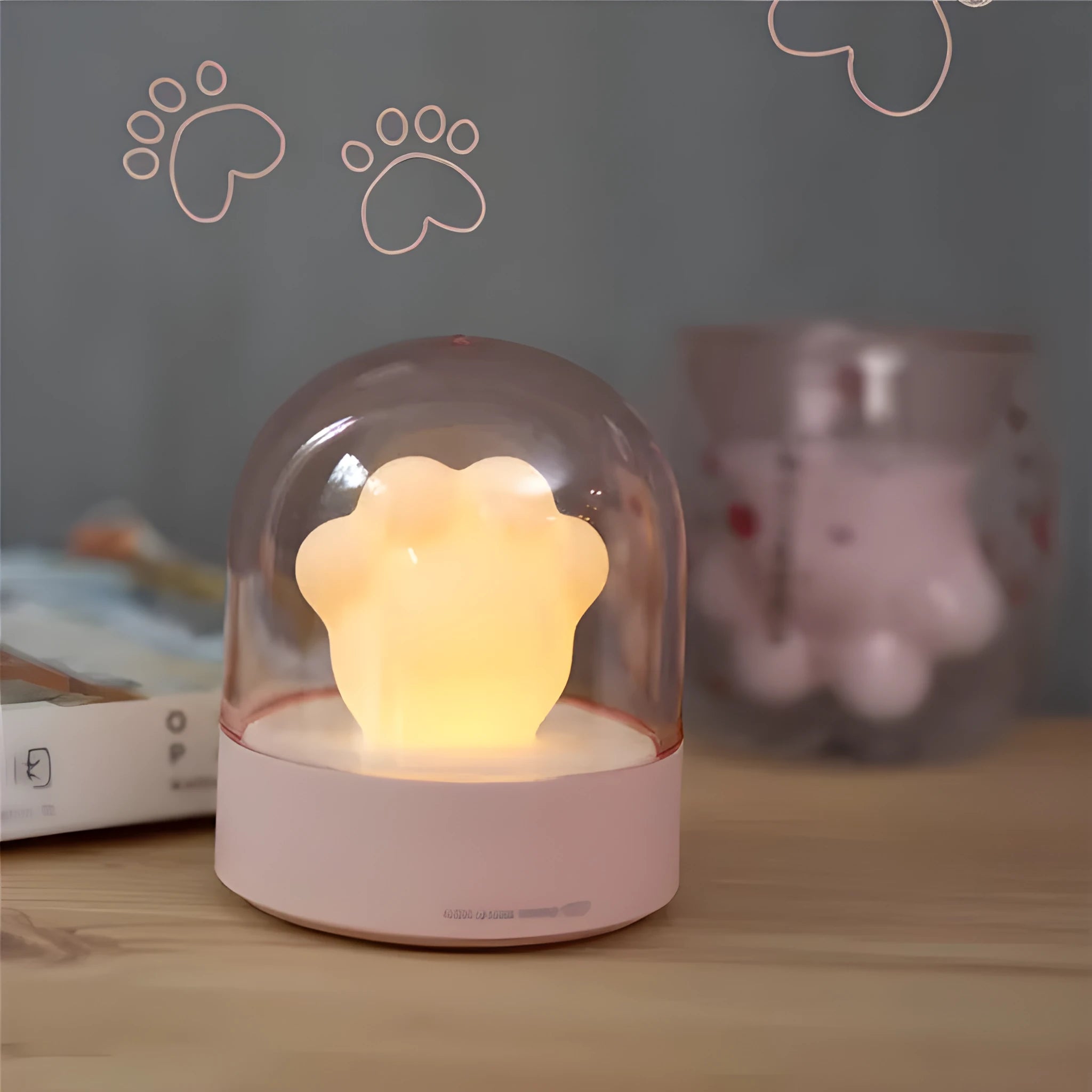 Grey cat paw shaped USB rechargeable musical night light on a wooden desk