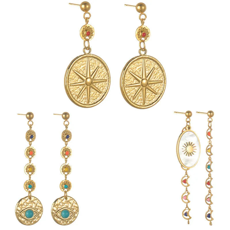 Three geometric stainless steel earrings showing star, eye and shell sun designs