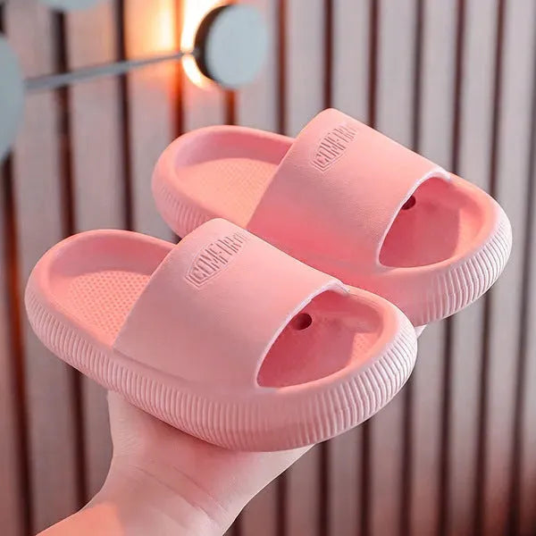 Bright coloured children's EVA slippers with textured sole, shown in blue, green, orange, pink, and yellow.