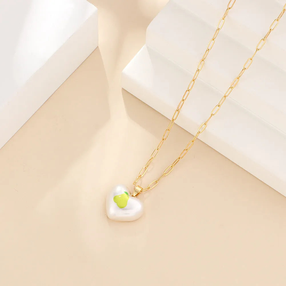 Geometric heart-shaped necklace with a detailed strawberry charm pendant on an adjustable chain.