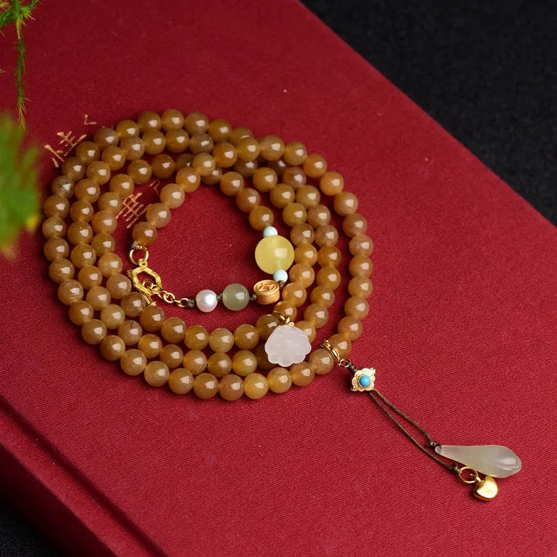 Women's jade bracelet with 6mm round beads showing clear water green pine pattern and leaf sequin accents