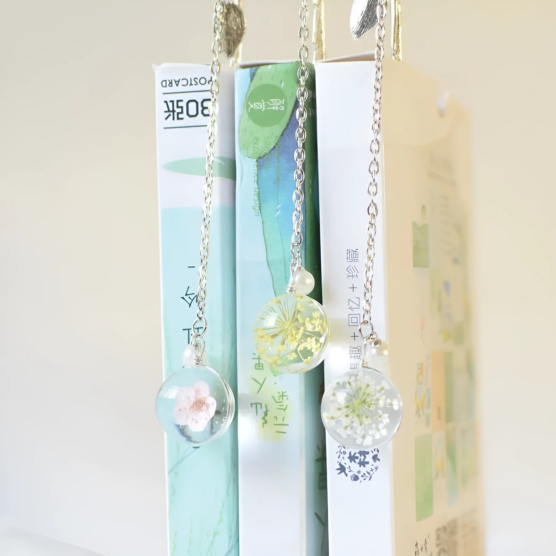 Creative metal bookmark with a dried flower inside, showing colour options like blue starry sky and dandelion.