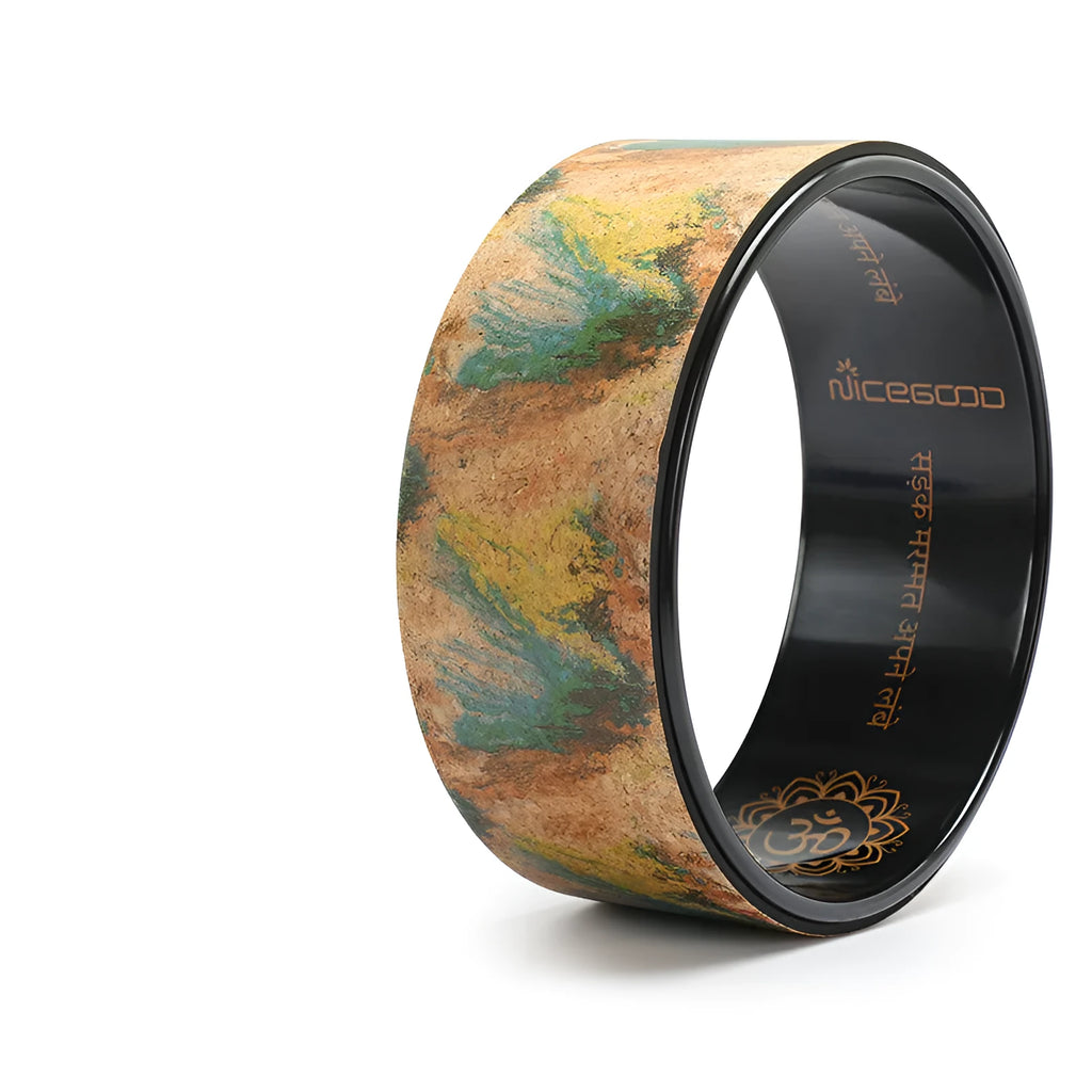 Cork yoga wheel in classic black, 32cm diameter, on a yoga mat in a home studio