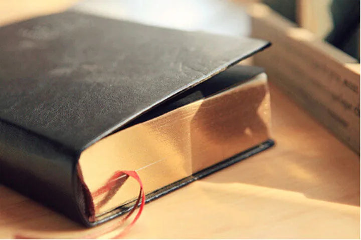 Large thick leather Phnom Penh notebook in gold, A6 size, 480 pages, open on a desk