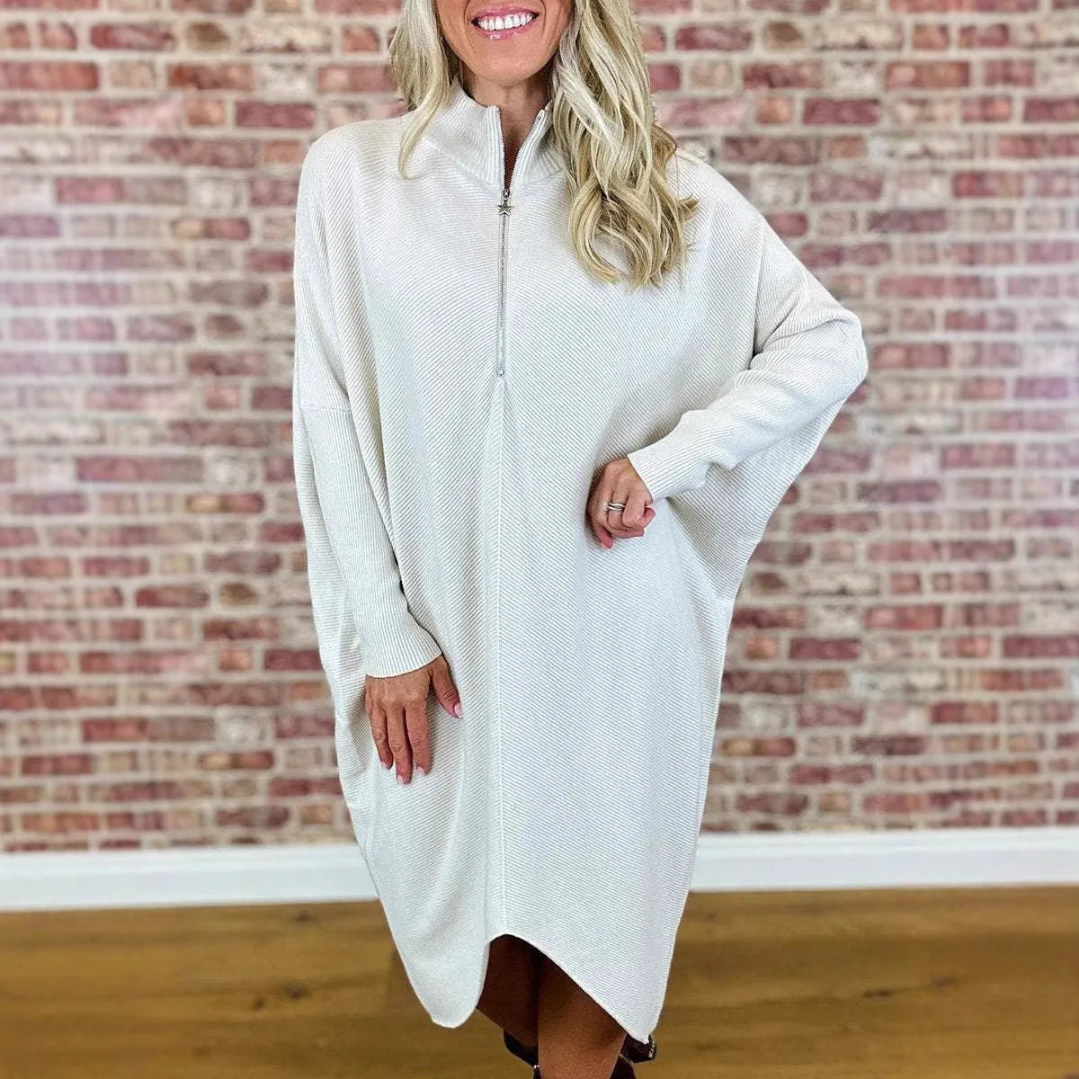 Women's solid colour loose fit knitted dress with raglan sleeves on a hanger.