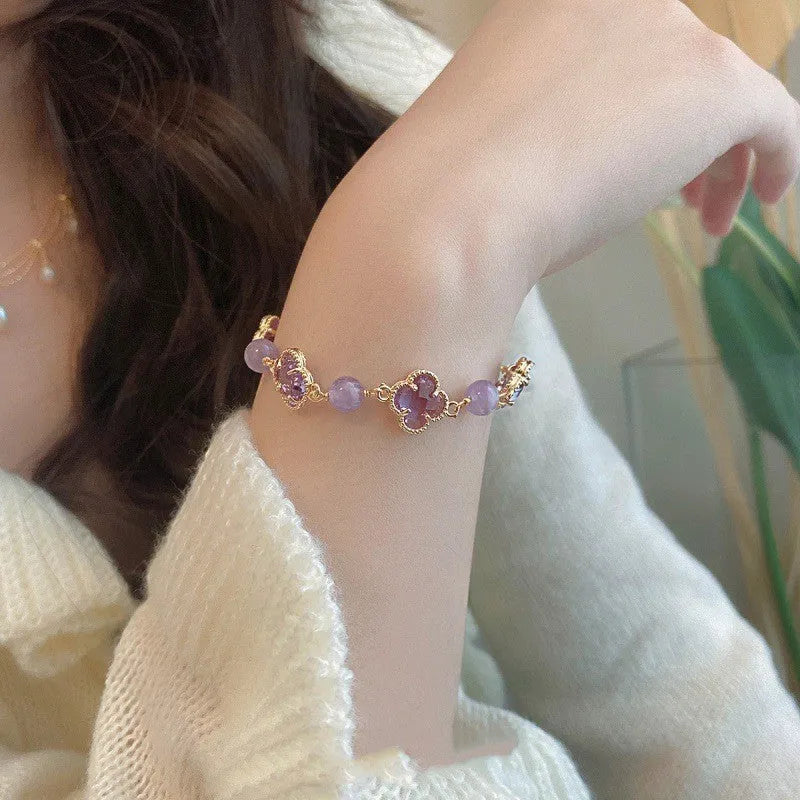 Women's artificial amethyst bracelet with four-leaf clover pendant and pearl accents on a U-shaped cuff.