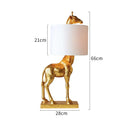 Giraffe table lamp with resin base and cloth shade, 66cm high, in white finish on a bedside table