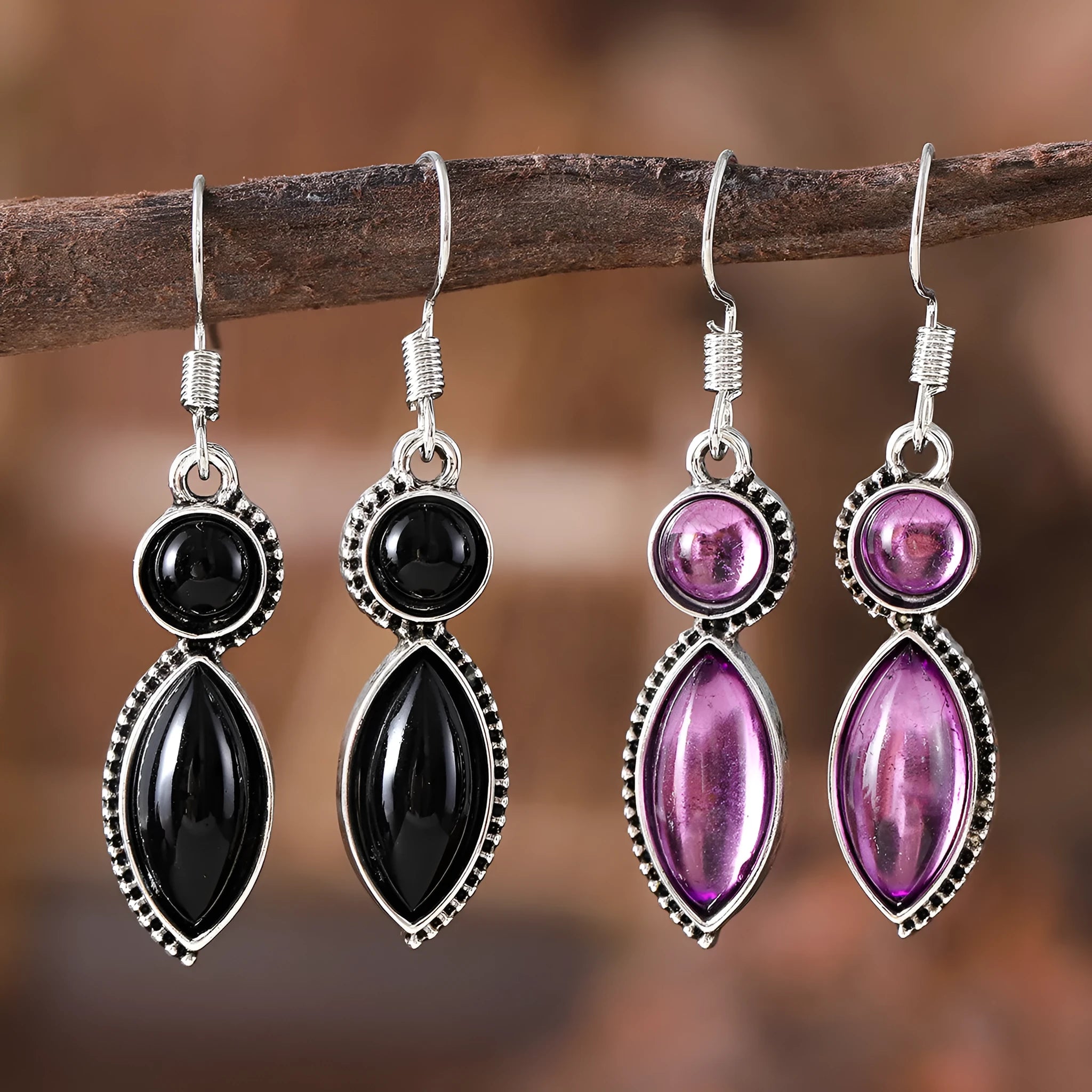 Close-up of geometric vintage pendant earrings in black and purple with a metallic shine.