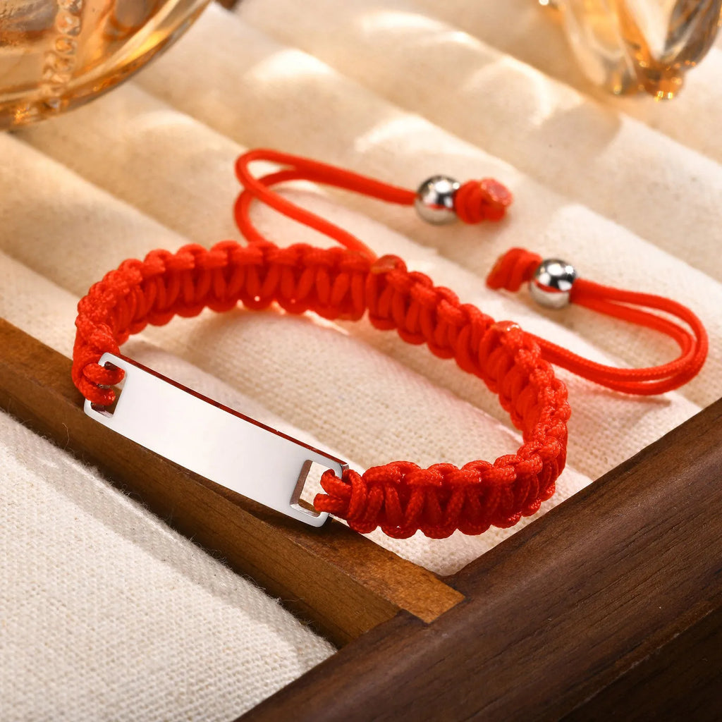 Stainless steel curved brand red nylon rope woven children's bracelet in rose gold on a white background