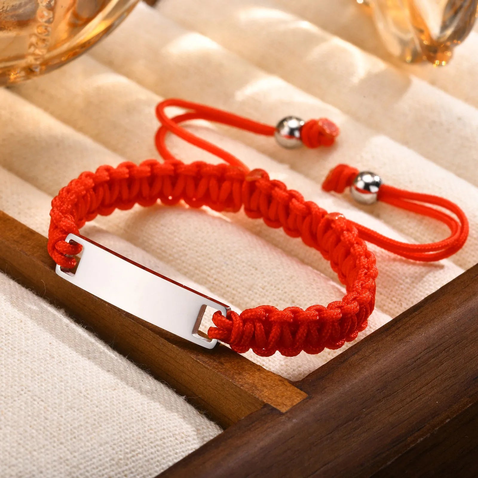 Stainless steel curved brand red nylon rope woven children's bracelet in rose gold on a white background