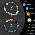 Set of two natural stone beaded bracelets with zodiac sign designs on a flat surface.