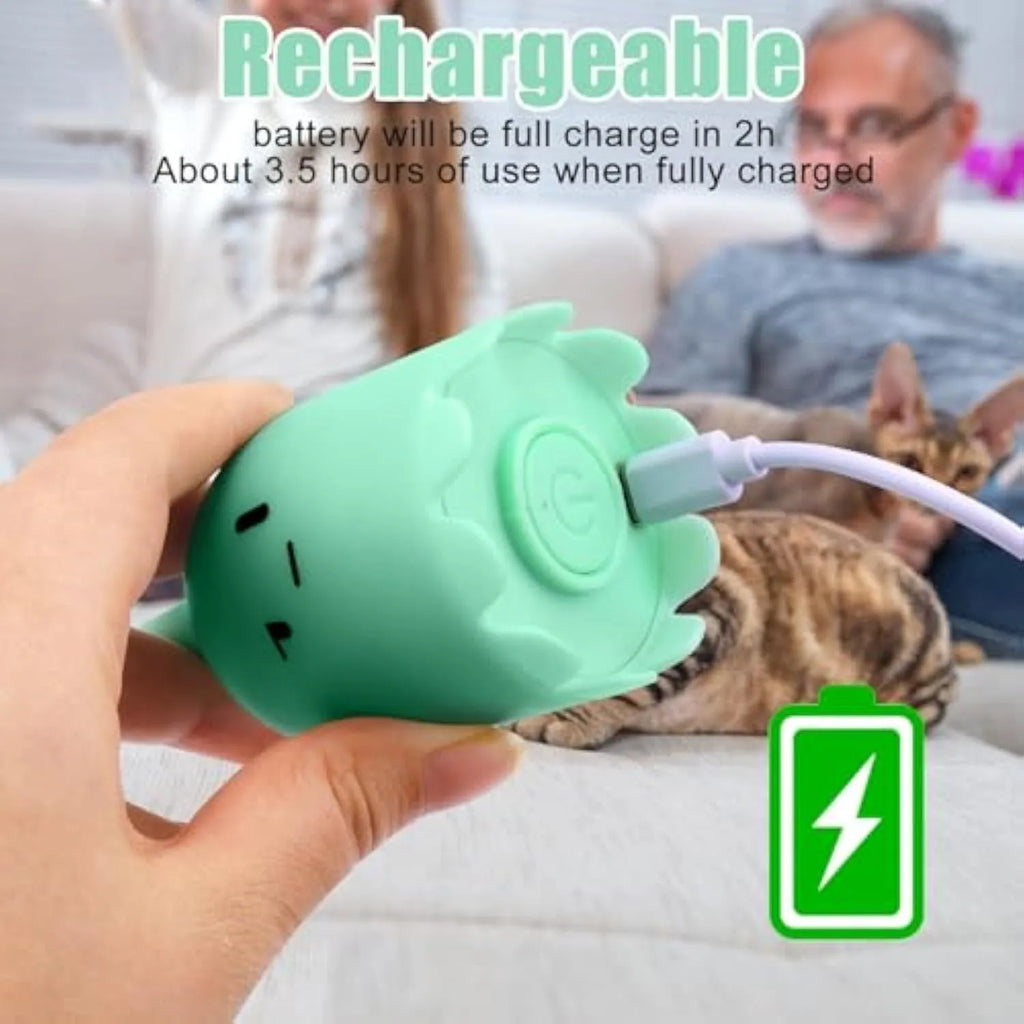 Green automatic cat wand toy with swinging silicone tails on a wooden floor.