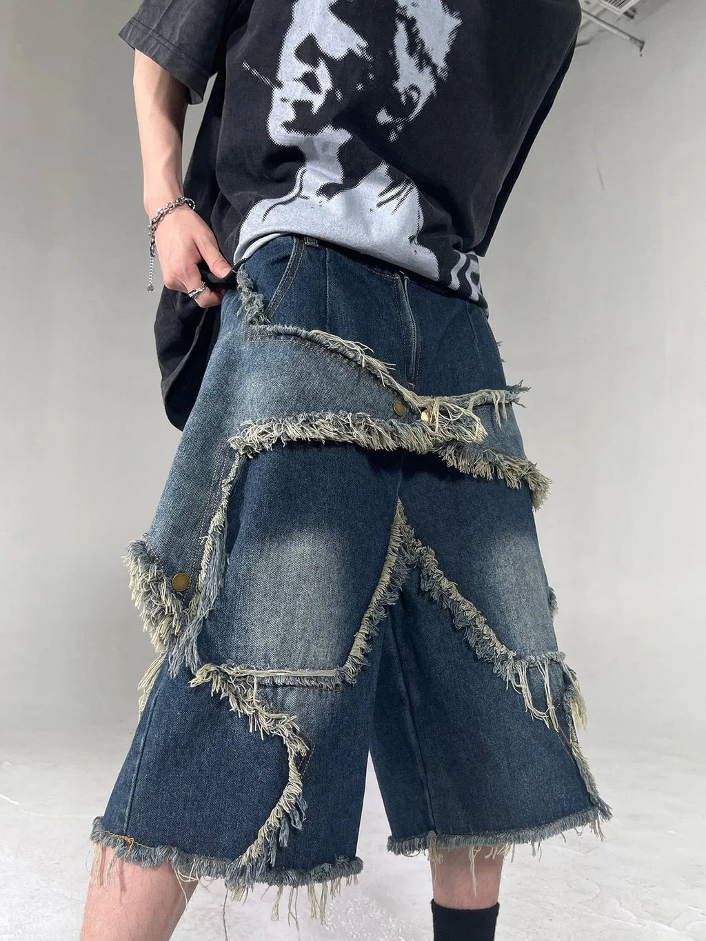 Men's blue denim shorts with frayed five-pointed star detailing and loose fit design