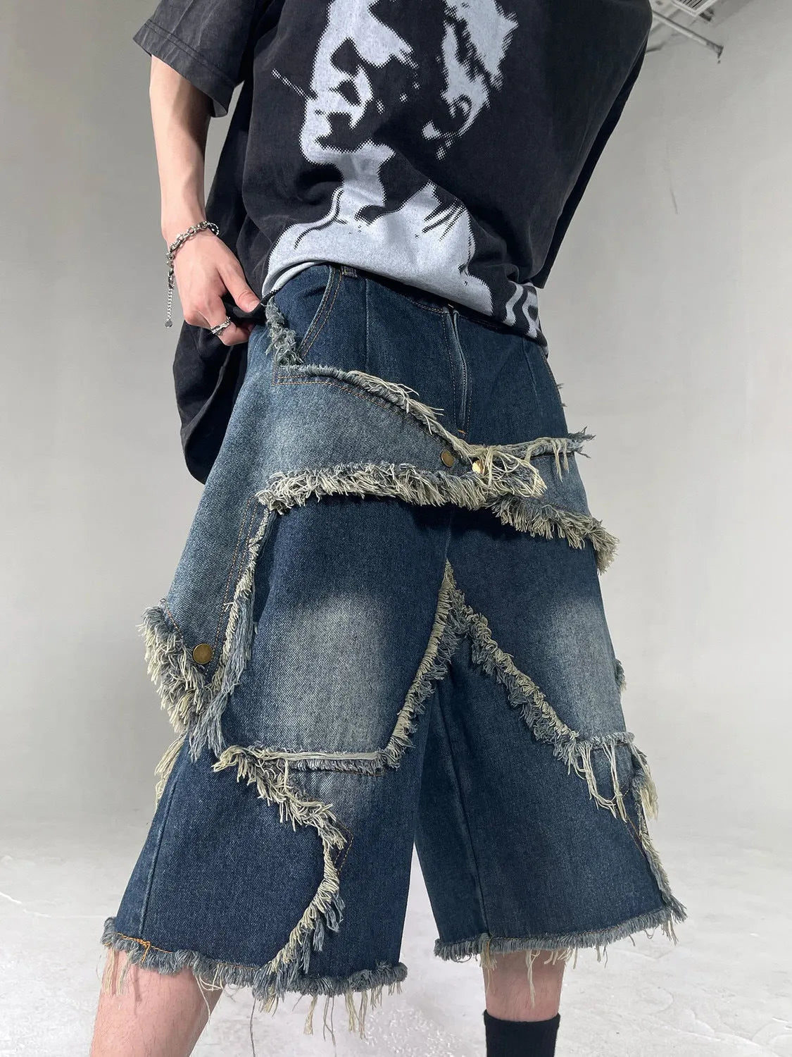 Men's blue denim shorts with frayed five-pointed star detailing and loose fit design