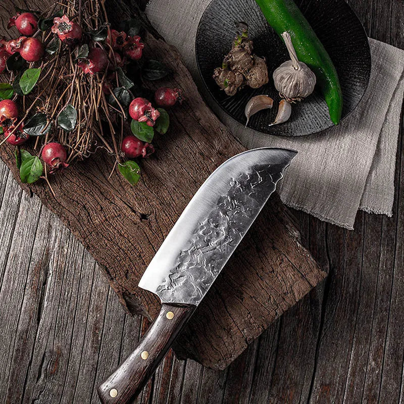 Hand forged stainless steel butcher knife with chicken wing wood handle and copper nails on a cutting board